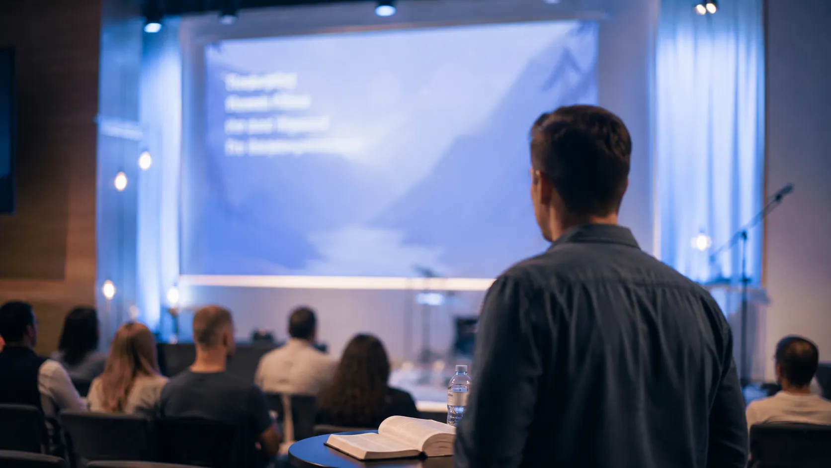 A congregation viewing sermon slides on a large screen